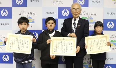 写真：市長と一緒に賞状をもって並ぶ第九小学校の児童3人と市長