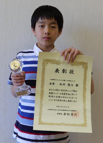 トロフィーと賞状を持つ松本さんの写真