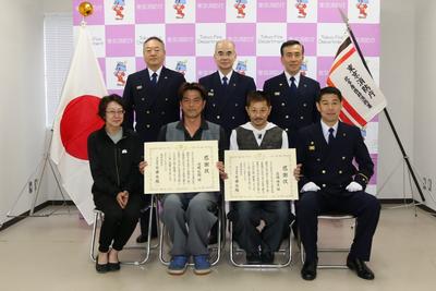 感謝状を持つ高橋さんと内堀さんと消防署職員との写真