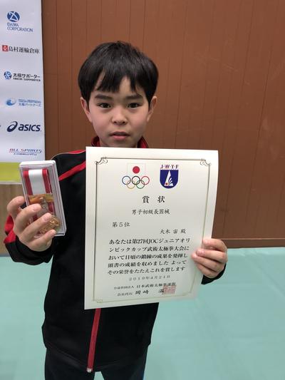 メダルと賞状を持つ大木さんの写真