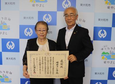 賞状をもち市長と写真を撮る増田さんの写真