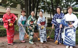 浴衣姿で打ち水をする女性たちの写真