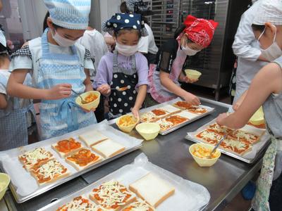 ピザトーストを作る体験をする子供たちの写真